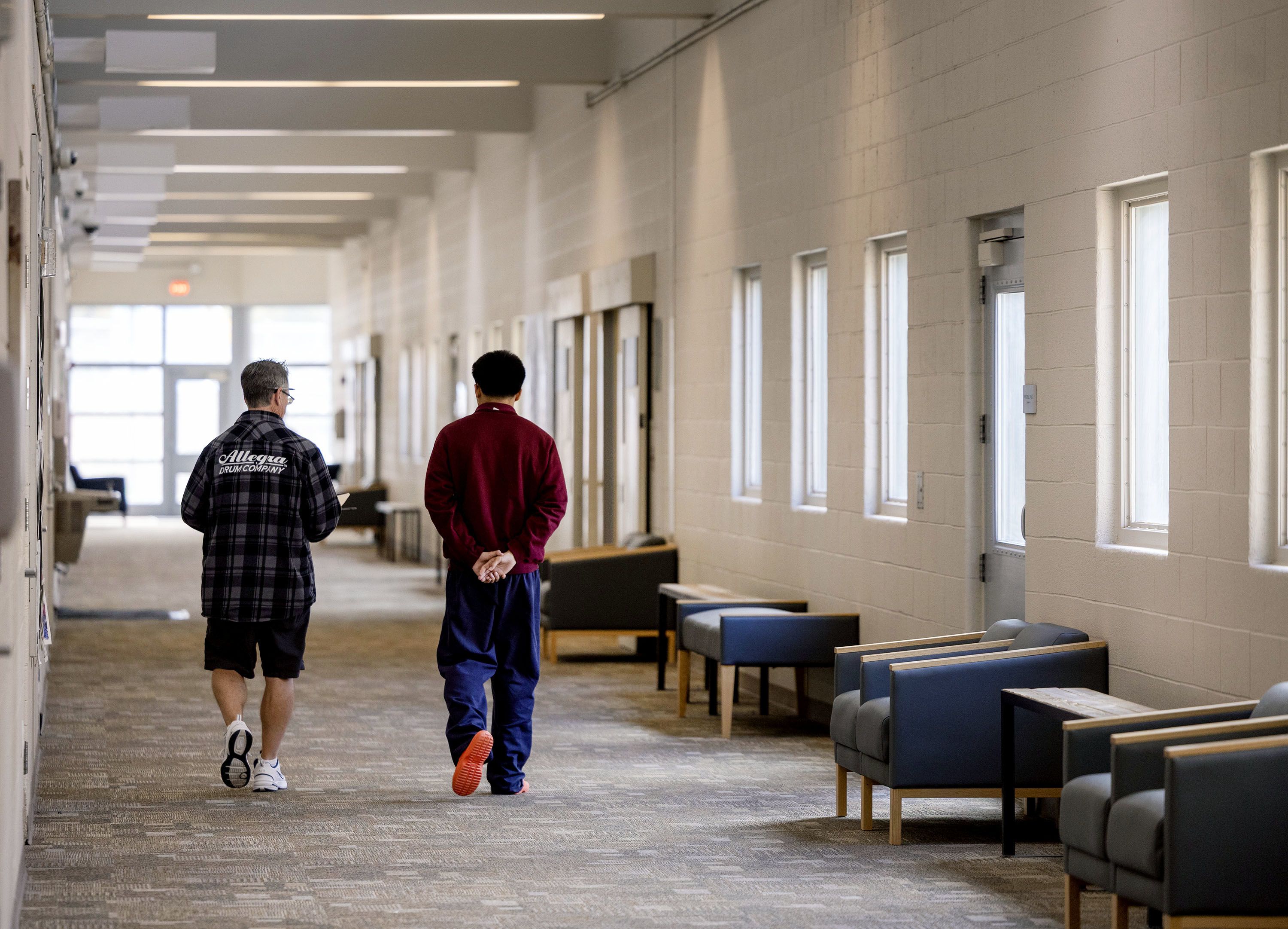 Two people walk down a classroom hallway inside the Salt Lake Valley Youth Center.
