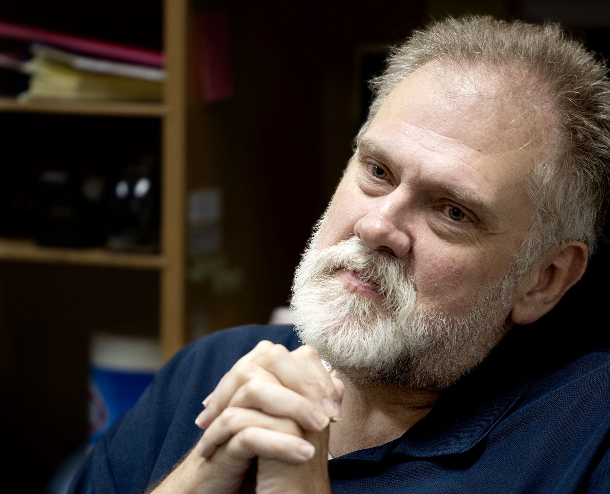 Russell Murdock, medical secretary at the Salt Lake Valley Youth Center clinic, folds his hands together inside the nurses' office. 