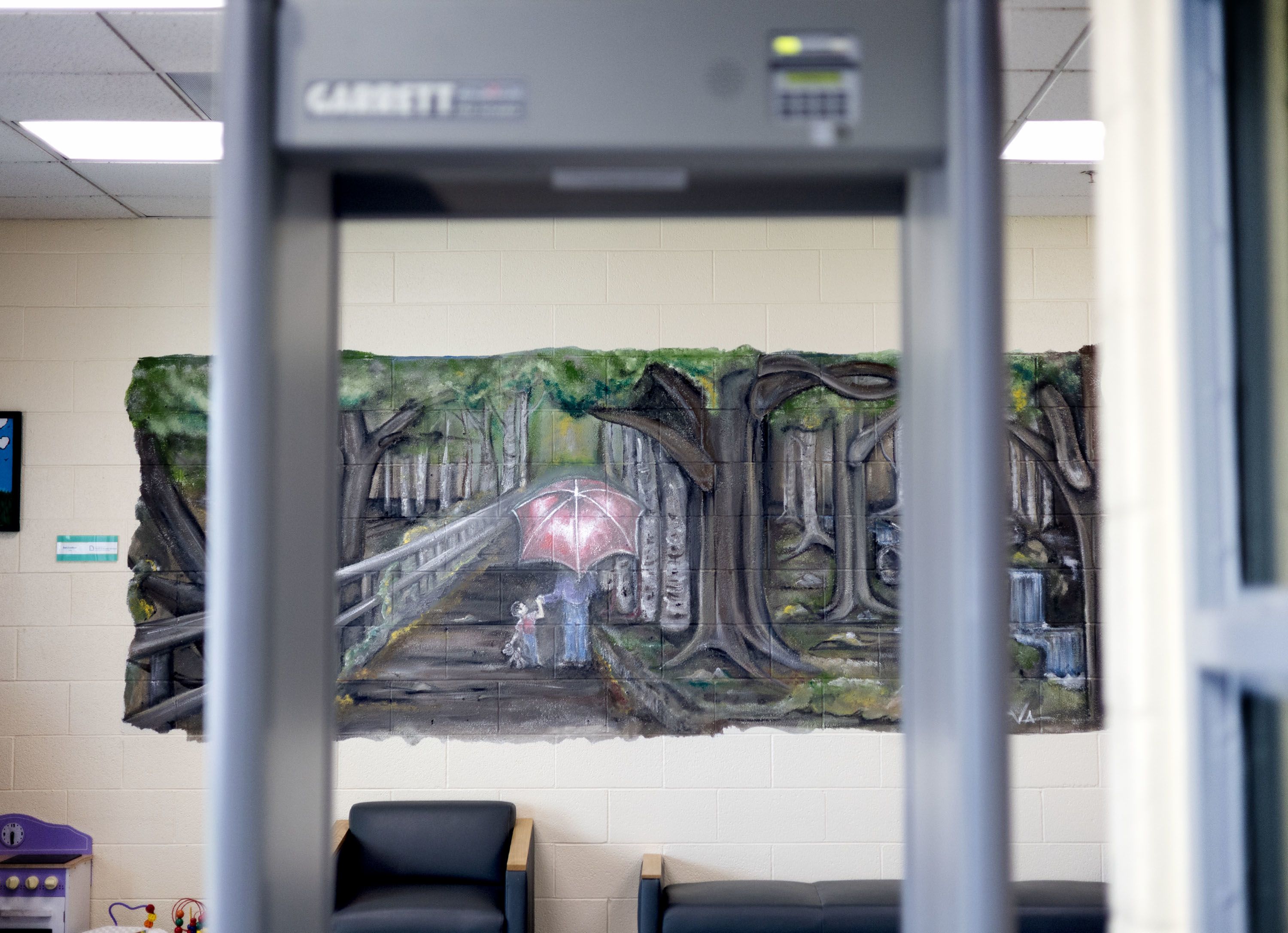 Looking through a metal detector onto a painting on the wall in the visitors' waiting room at Salt Lake Valley Youth Center, a detention facility in South Salt Lake. 
