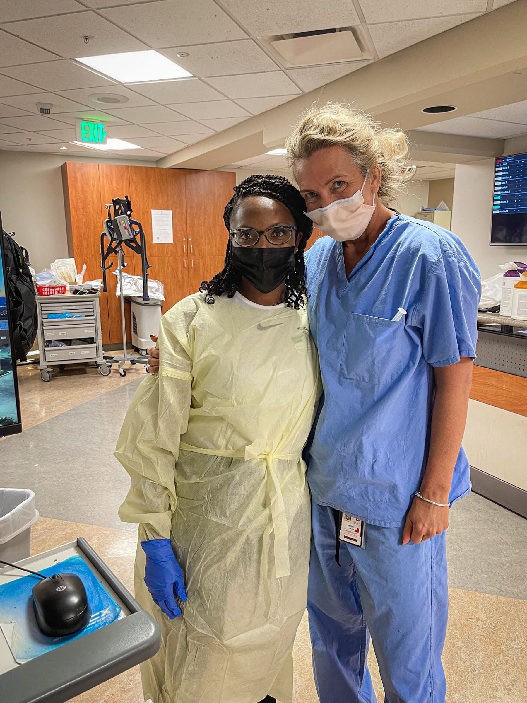 Nakia Hall in a surgical gown stands next to Nurse Brittnee Zacherson.