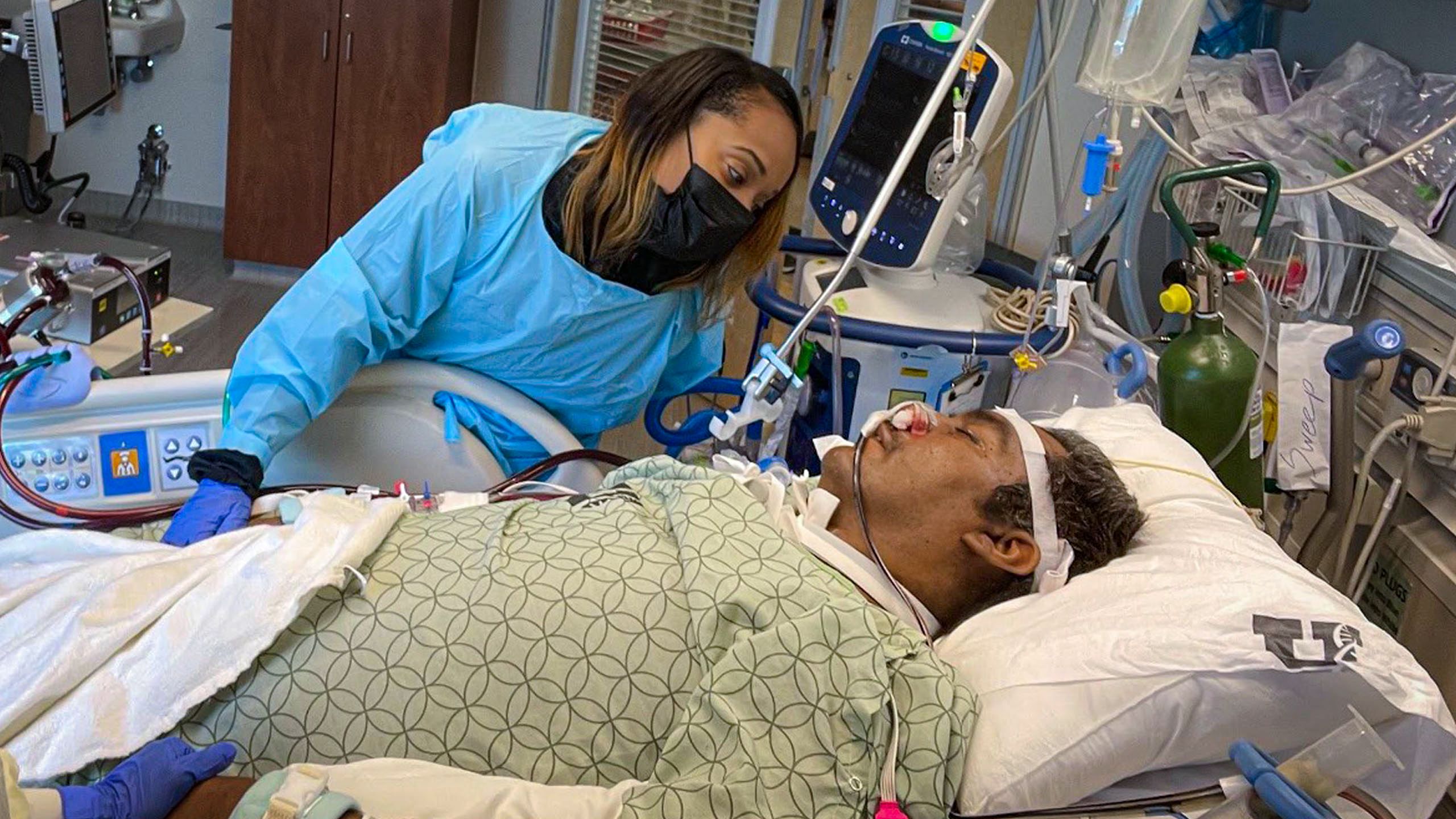 LaShonda Arocha prays over her husband Manny in a University of Utah ICU bed.