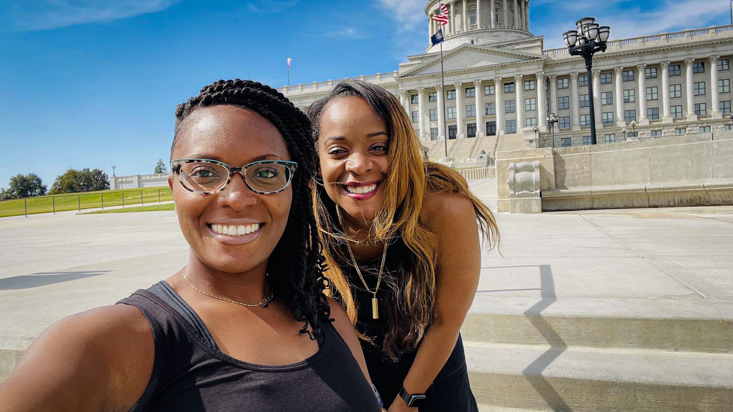 Nakia takes a close selfie of herself and her sister smiling ecstatically in front of the Utah State Capitol building.