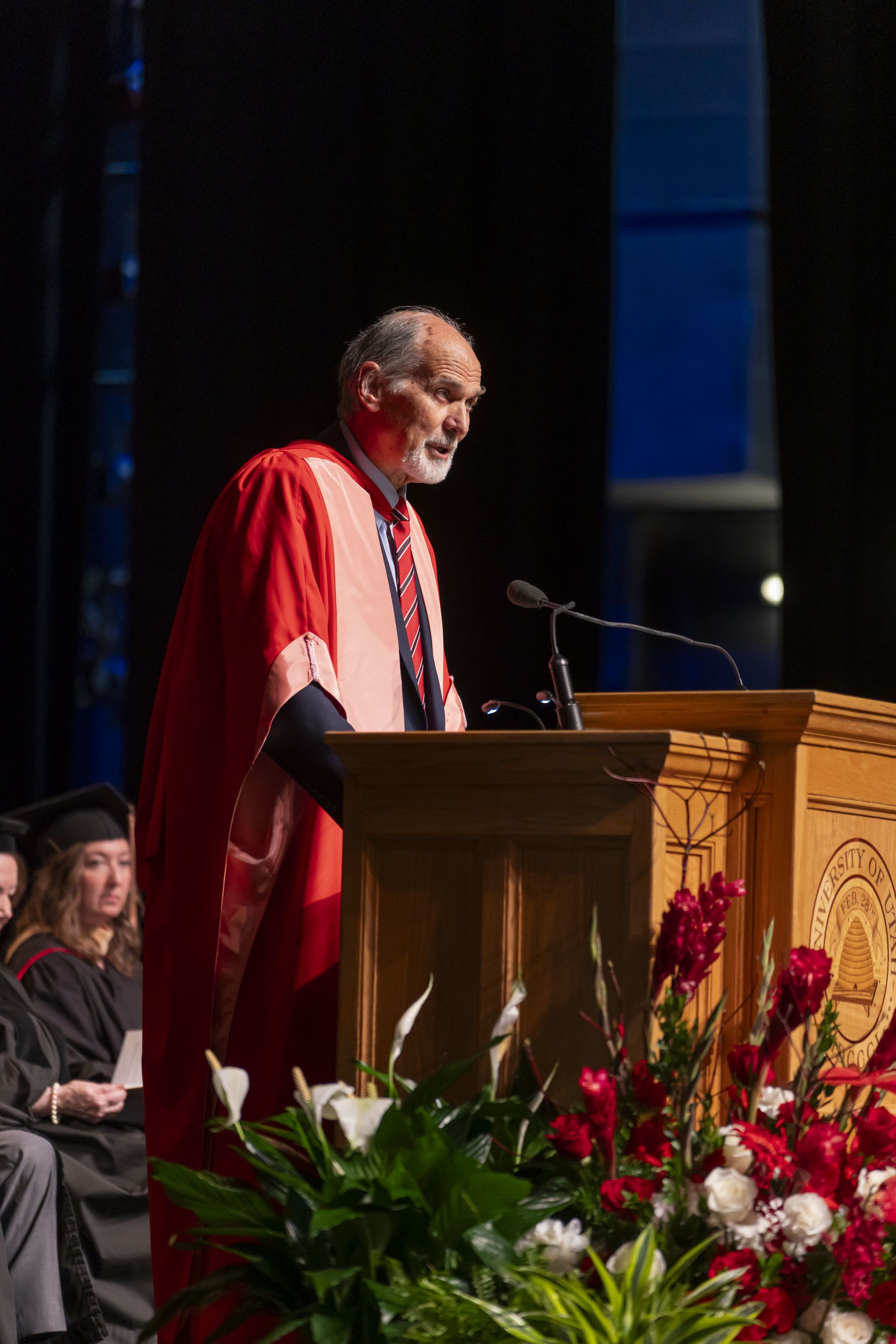 In a red gown and bareheaded, Dean Hume spoke to the school's 2024 graduates from the Kingsbury Hall stage about what their year had achieved.