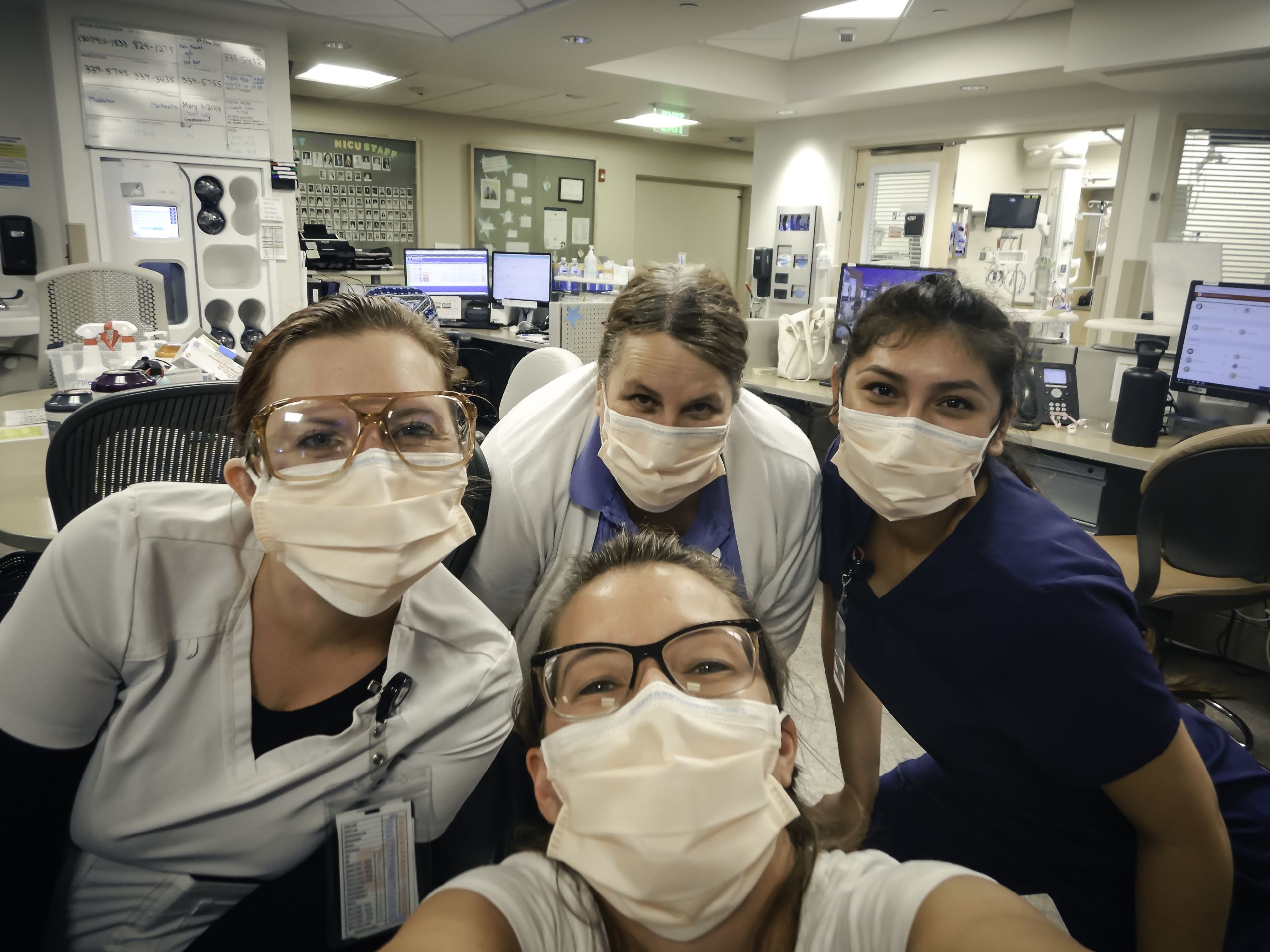 Four MICU staff members pose for a selfie while wearing masks.